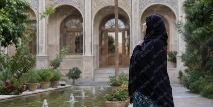 زن با چادر در حیاط خانه سنتی ایرانی